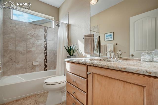 12442 Carmel Ridge Road Colorado Springs, CO 80921 - Photo 28 of 50 Full bathroom with vanity, shower / tub combo with curtain, tile patterned floors, and toilet