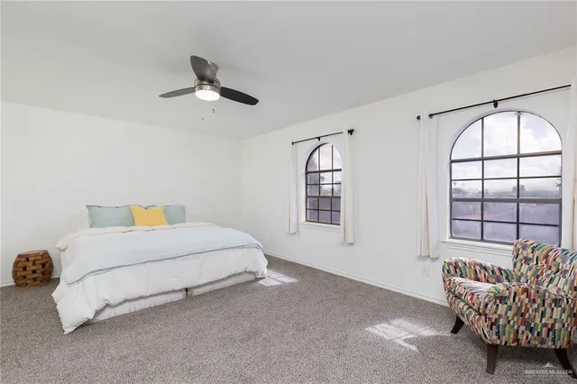 a spacious bedroom with a bed and a window