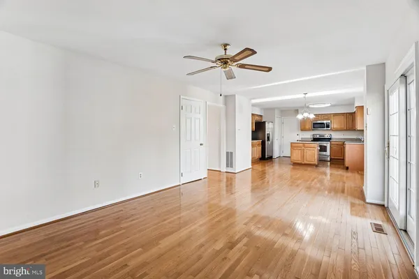 a view of a big room with wooden floor and a kitchen
