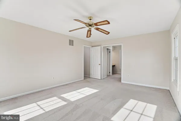 a view of empty room with ceiling fan