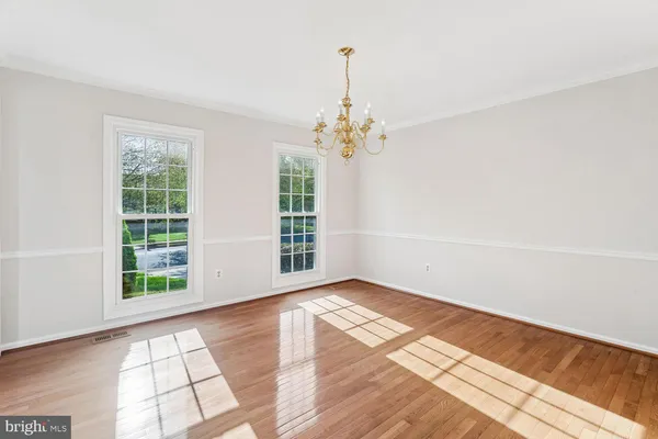 a view of an empty room with glass door and wooden floor