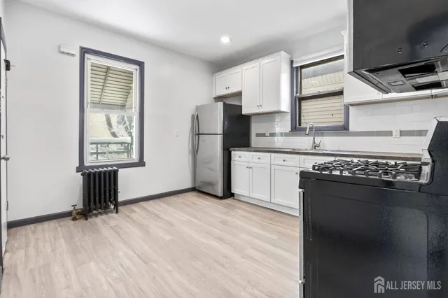 a kitchen with stainless steel appliances granite countertop a stove a refrigerator and a microwave