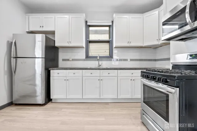 a kitchen with white cabinets and white appliances