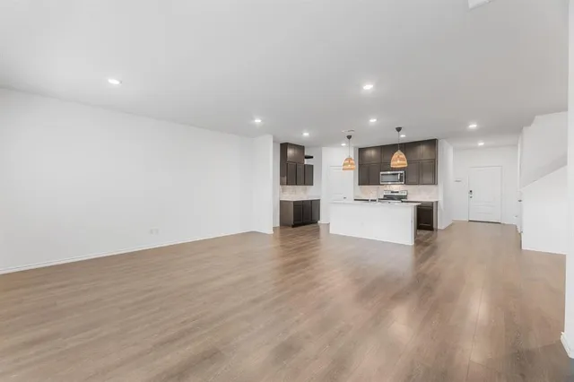 a view of kitchen with kitchen island granite countertop a stove top oven and a sink with granite countertops