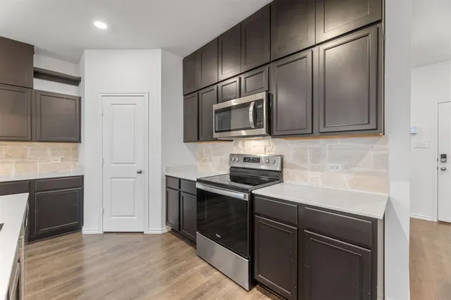 a kitchen with stainless steel appliances granite countertop a refrigerator and a stove top oven