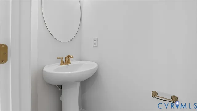 a bathroom with a sink a mirror and a wooden floor