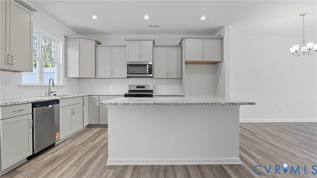 a kitchen with kitchen island white cabinets appliances and a sink