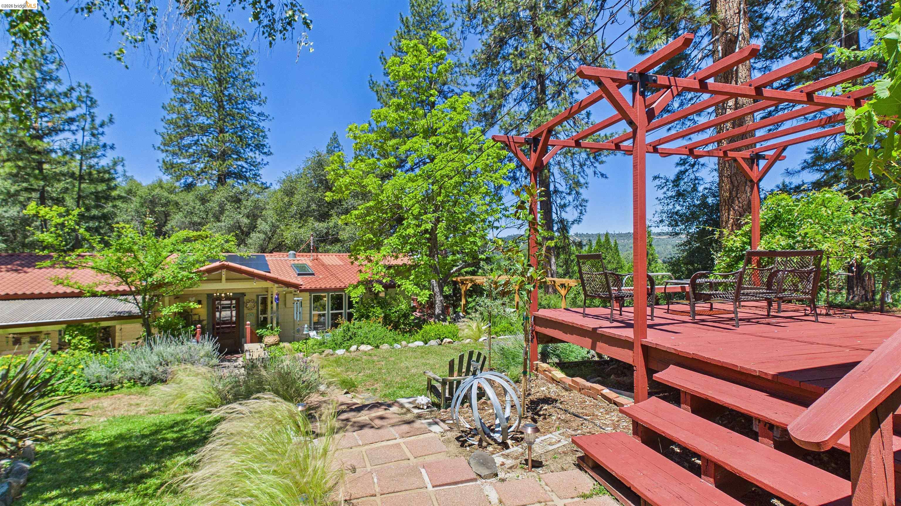 18102 Mt Eaton Road Tuolumne, CA 95379 - Photo 28 of 44 Red-stained wooden deck featuring a pergola structure and steps