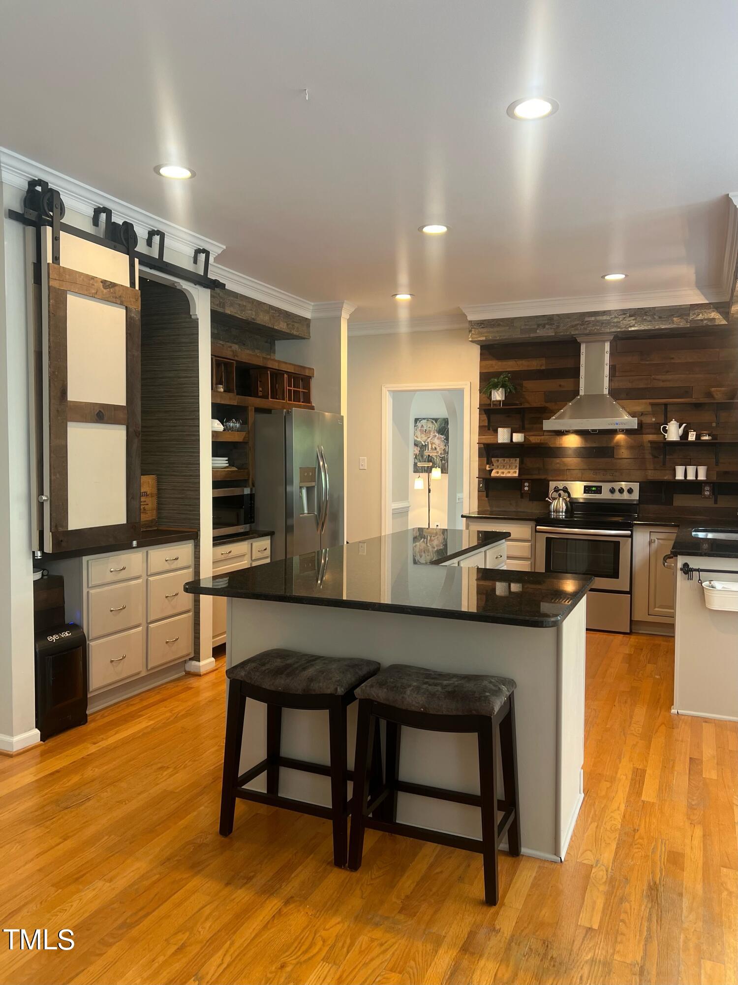 107 Whitney Lane Durham, NC 27713 - Photo 10 of 42 a kitchen with stainless steel appliances kitchen island granite countertop a table chairs sink and stove