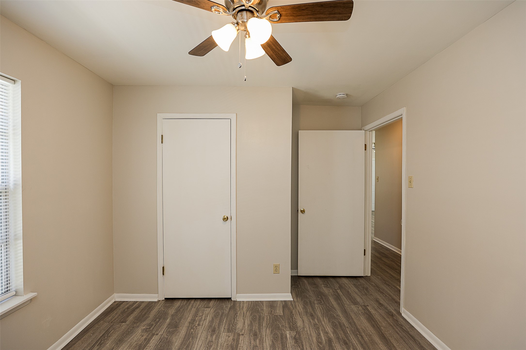 7810 Queen Street Houston, TX 77028 - Photo 15 of 21 This is a well-lit, second bedroom, featuring a ceiling fan, and laminate wood flooring.