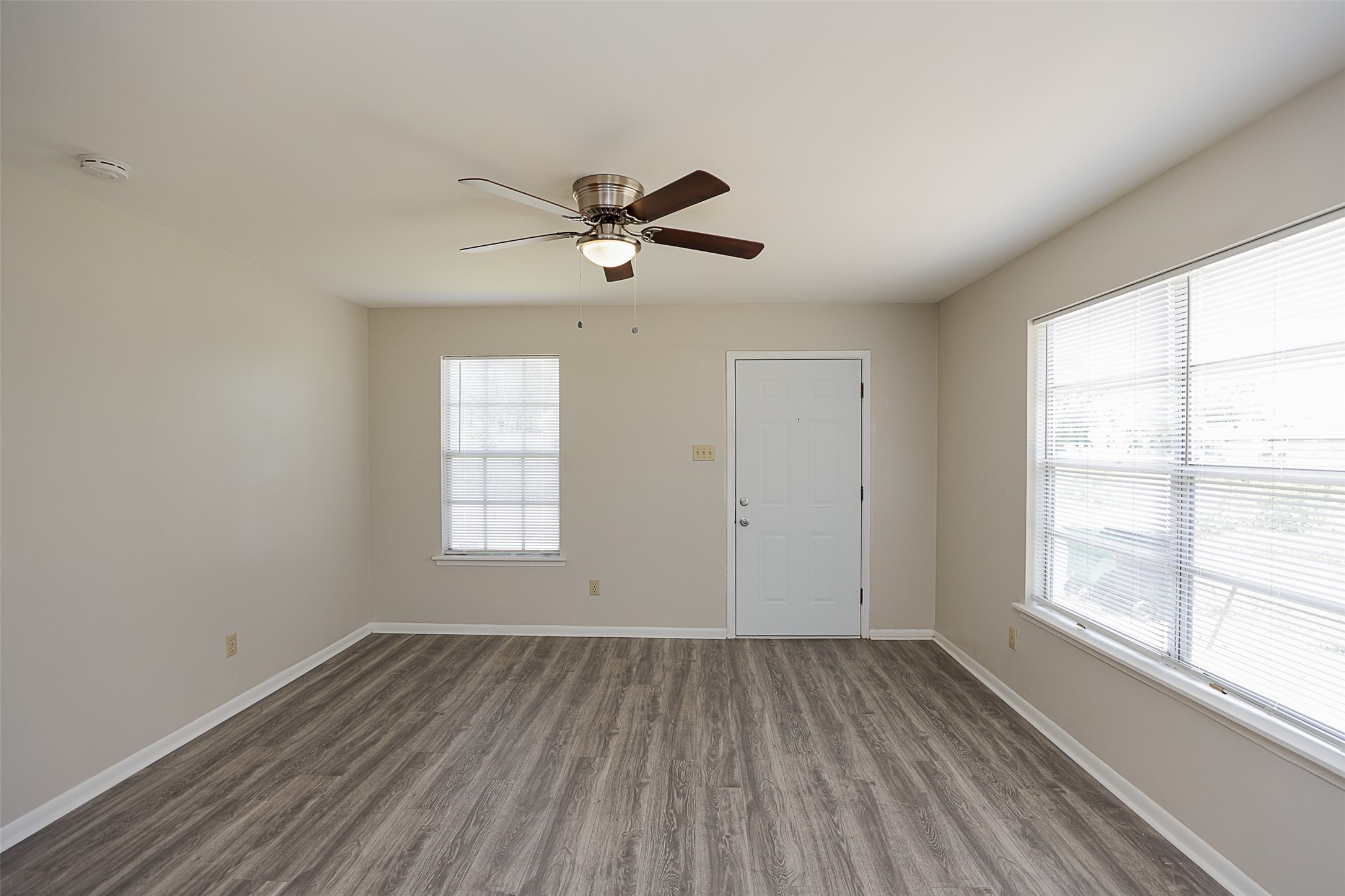 7810 Queen Street Houston, TX 77028 - Photo 4 of 21 This is a bright, living room featuring neutral wall colors, modern wood-look flooring, two windows providing natural light, and a ceiling fan for added comfort. .