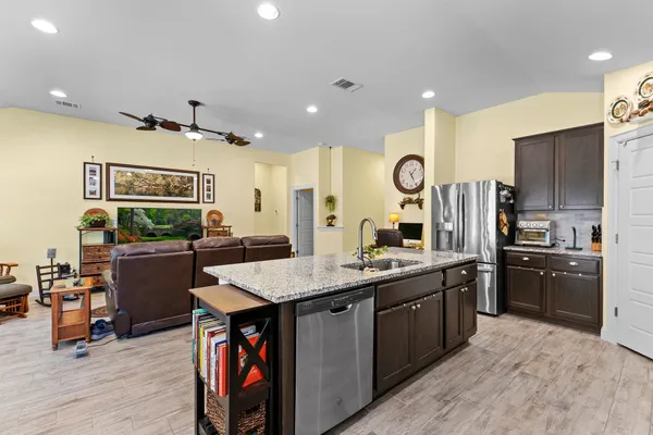 a kitchen with stainless steel appliances granite countertop a sink a stove and a refrigerator