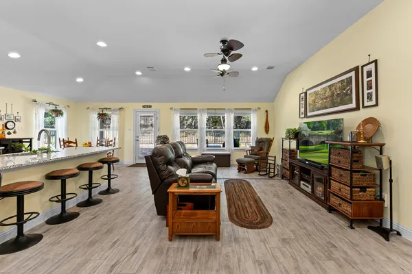 a living room with furniture a wooden floor and potted plants
