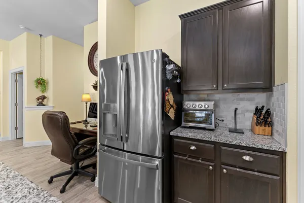 a kitchen with stainless steel appliances granite countertop a refrigerator and a stove top oven