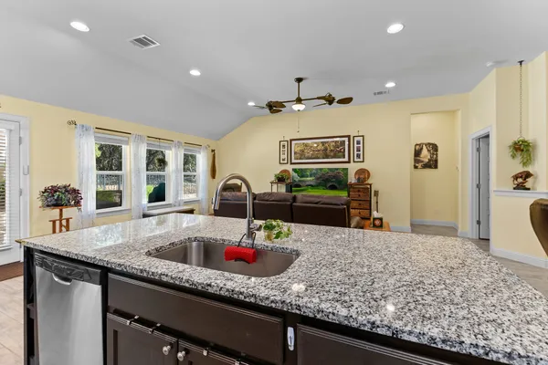 a kitchen with stainless steel appliances granite countertop a sink and white cabinets