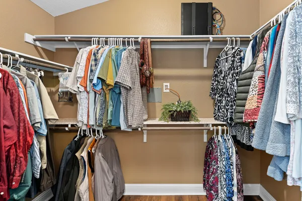 a view of walk in closet with clothes and shoes