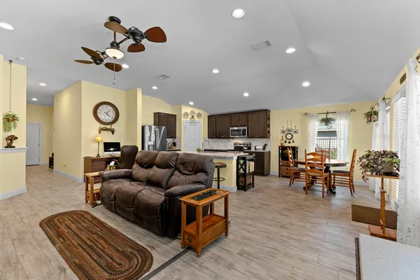a living room with furniture kitchen view and a chandelier