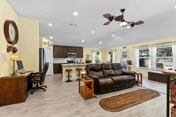 a living room with furniture and kitchen view