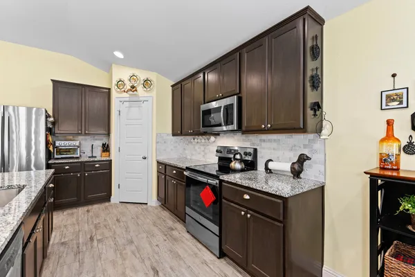 a kitchen with stainless steel appliances granite countertop a stove refrigerator sink and microwave