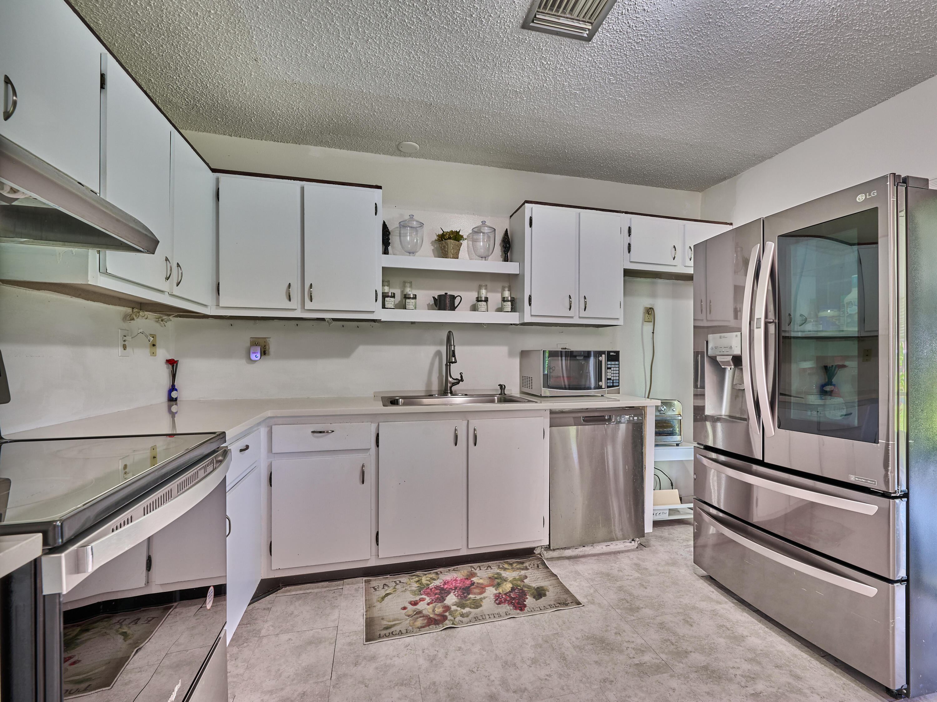 5197 Minto Road Boynton Beach, FL 33472 - Photo 13 of 32 a kitchen with stainless steel appliances granite countertop a refrigerator and white cabinets