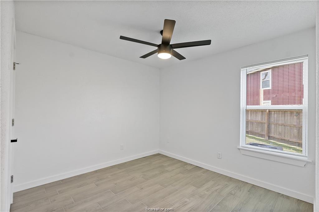 1503 Alpine Circle, Unit B College Station, TX 77840 - Photo 11 of 15 an empty room with a window and a ceiling fan