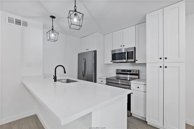 a kitchen with stainless steel appliances a stove refrigerator sink and microwave