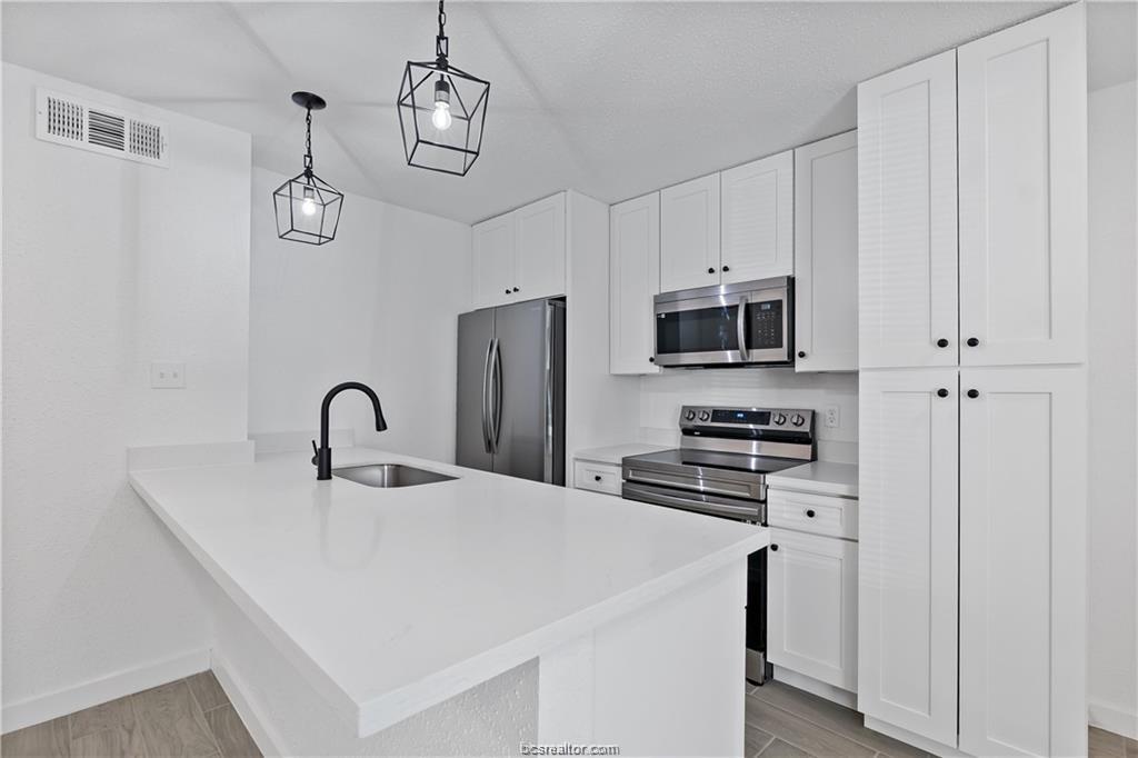 1503 Alpine Circle, Unit B College Station, TX 77840 - Photo 8 of 15 a kitchen with stainless steel appliances a stove refrigerator sink and microwave