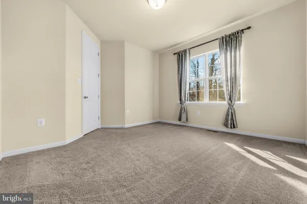 a spacious bedroom with a bed and a window