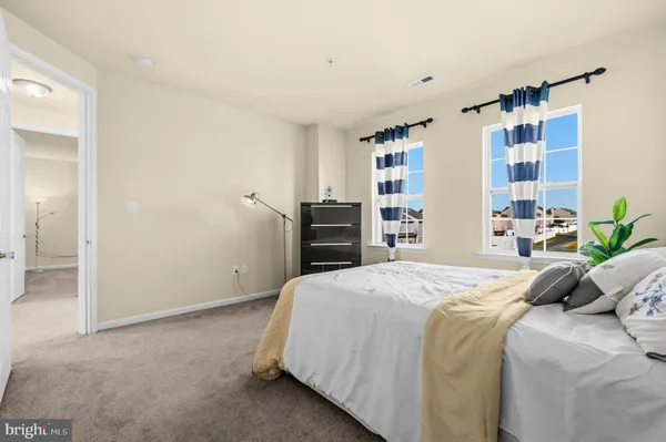 a spacious bedroom with a bed a couch and large window