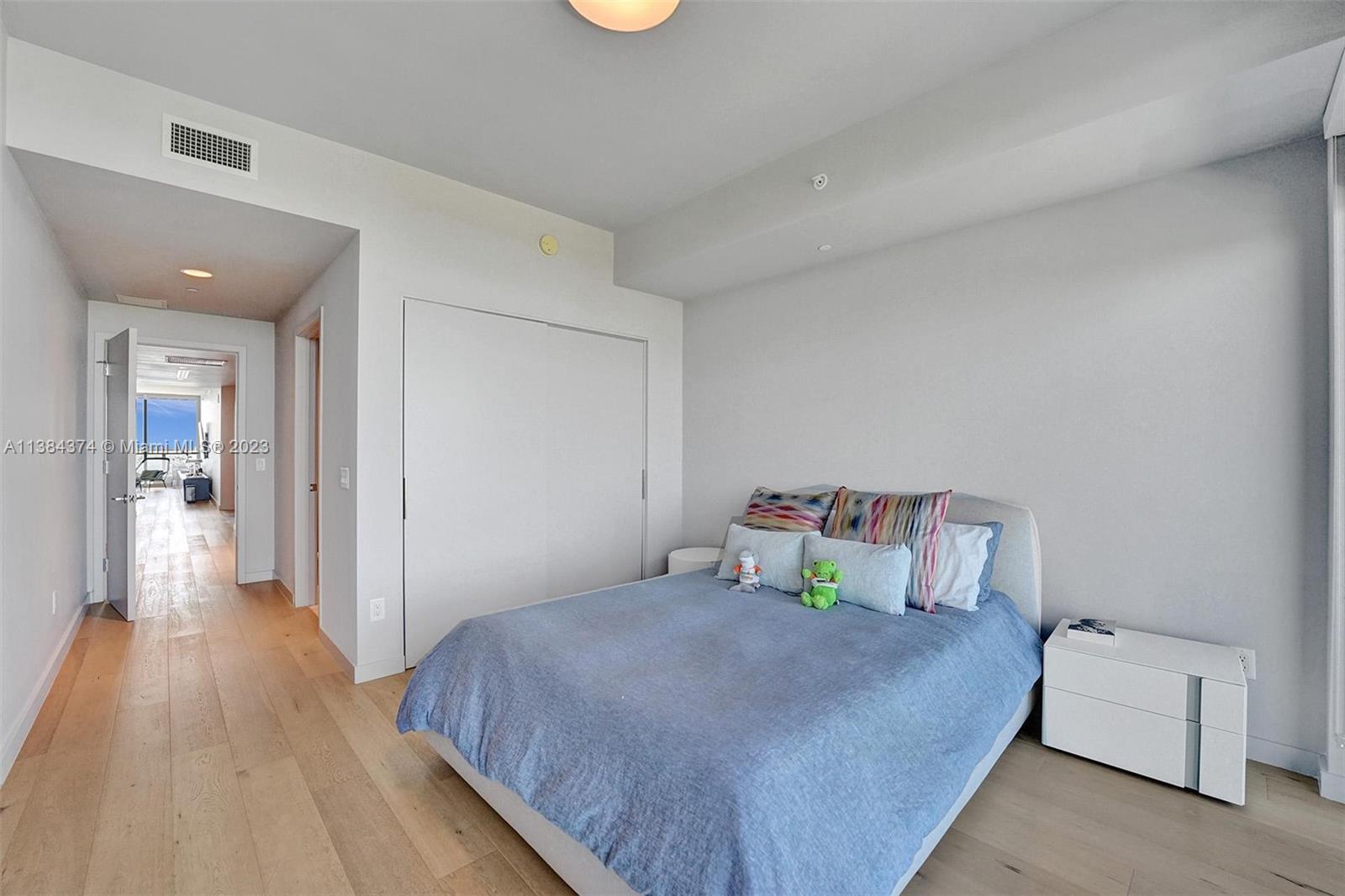 360 Ocean Drive, Unit 906S Key Biscayne, FL 33149 - Photo 16 of 33 a bedroom with a bed and wooden floor