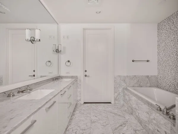 a spacious bathroom with a tub sink and mirror