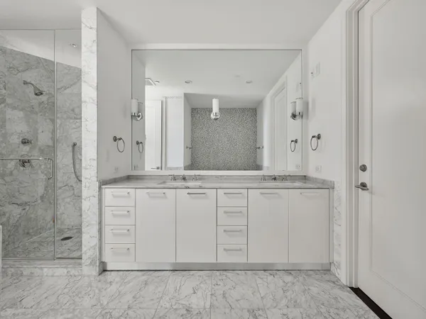 a bathroom with a granite countertop sink mirror and shower