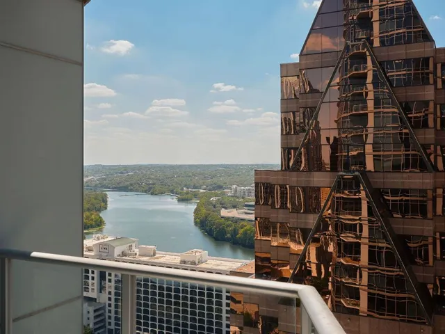 a roof deck with tall buildings and ocean view