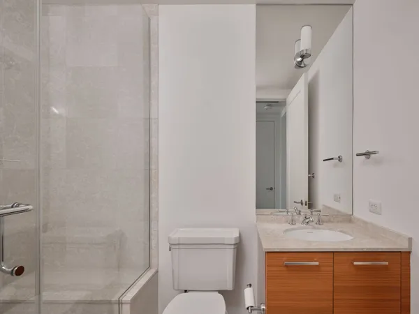 a bathroom with a granite countertop sink a toilet and shower