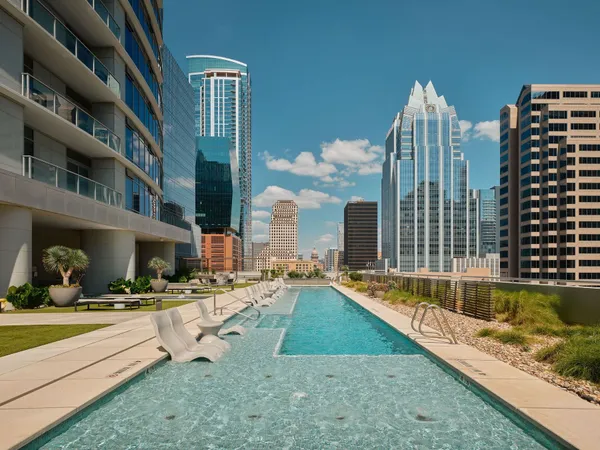 a roof deck with tall buildings and ocean view