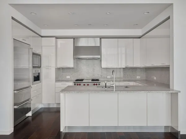 a kitchen with stainless steel appliances granite countertop a refrigerator and a stove top oven