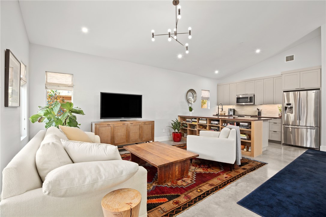a living room with furniture kitchen view and a window