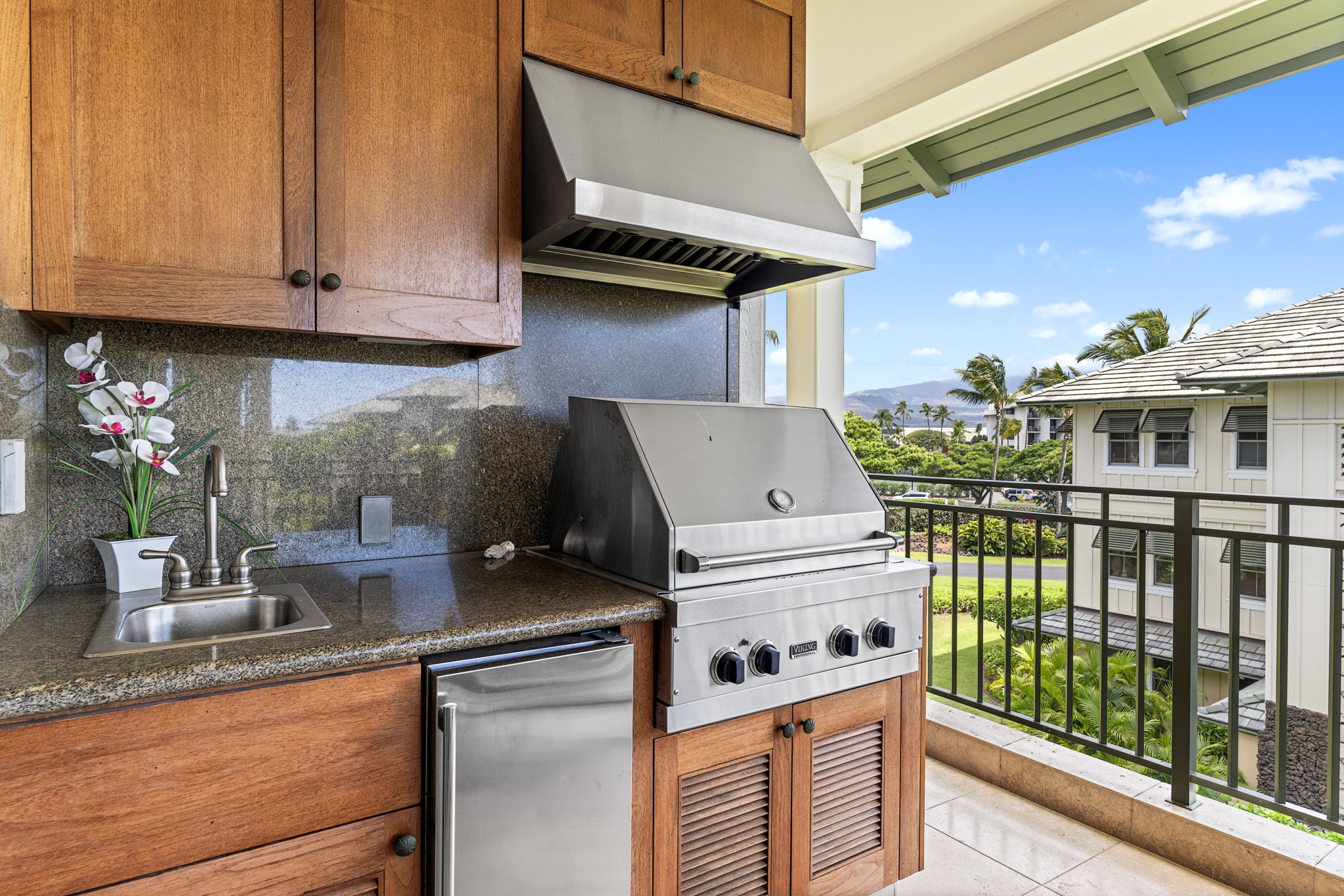 69-1000 Kolea Kai Circle, Unit 16J Waikoloa, HI 96738 - Photo 18 of 25 a kitchen with stainless steel appliances granite countertop a stove a sink and a microwave