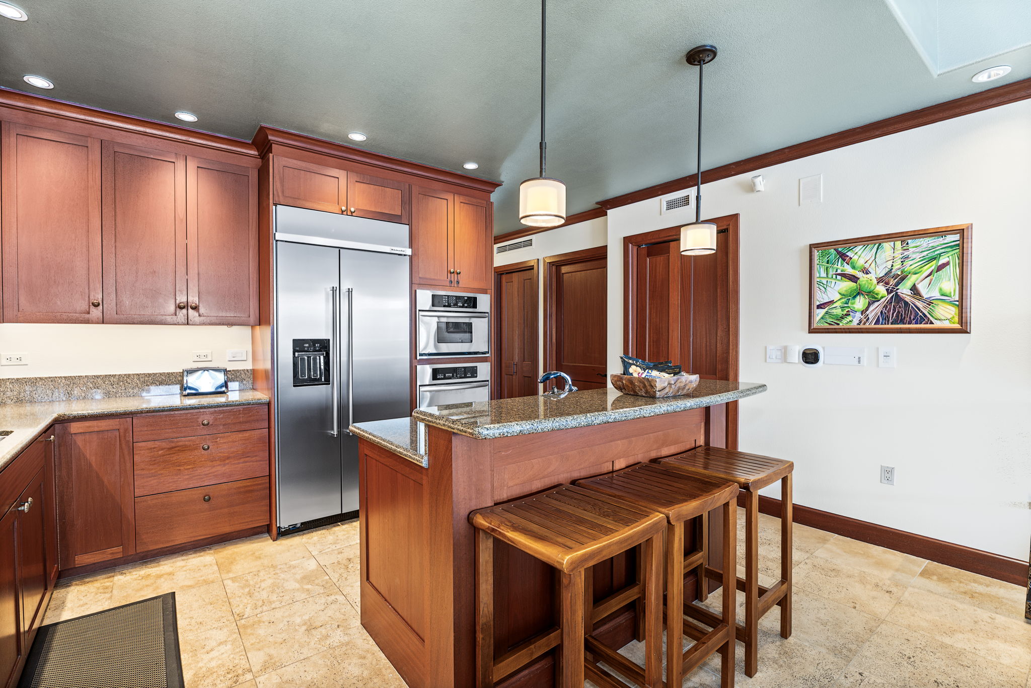 69-1000 Kolea Kai Circle, Unit 16J Waikoloa, HI 96738 - Photo 8 of 25 a kitchen with stainless steel appliances kitchen island granite countertop a refrigerator and a stove top oven