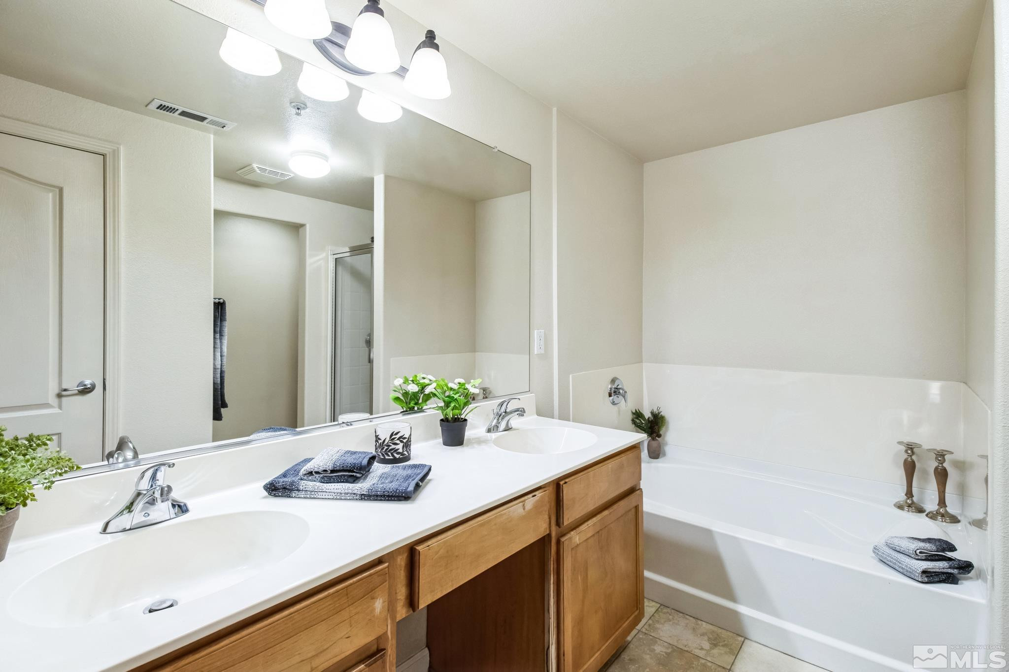 9050 Double R Boulevard, Unit 1412 Reno, NV 89521 - Photo 12 of 18 a bathroom with a sink vanity tub and a mirror