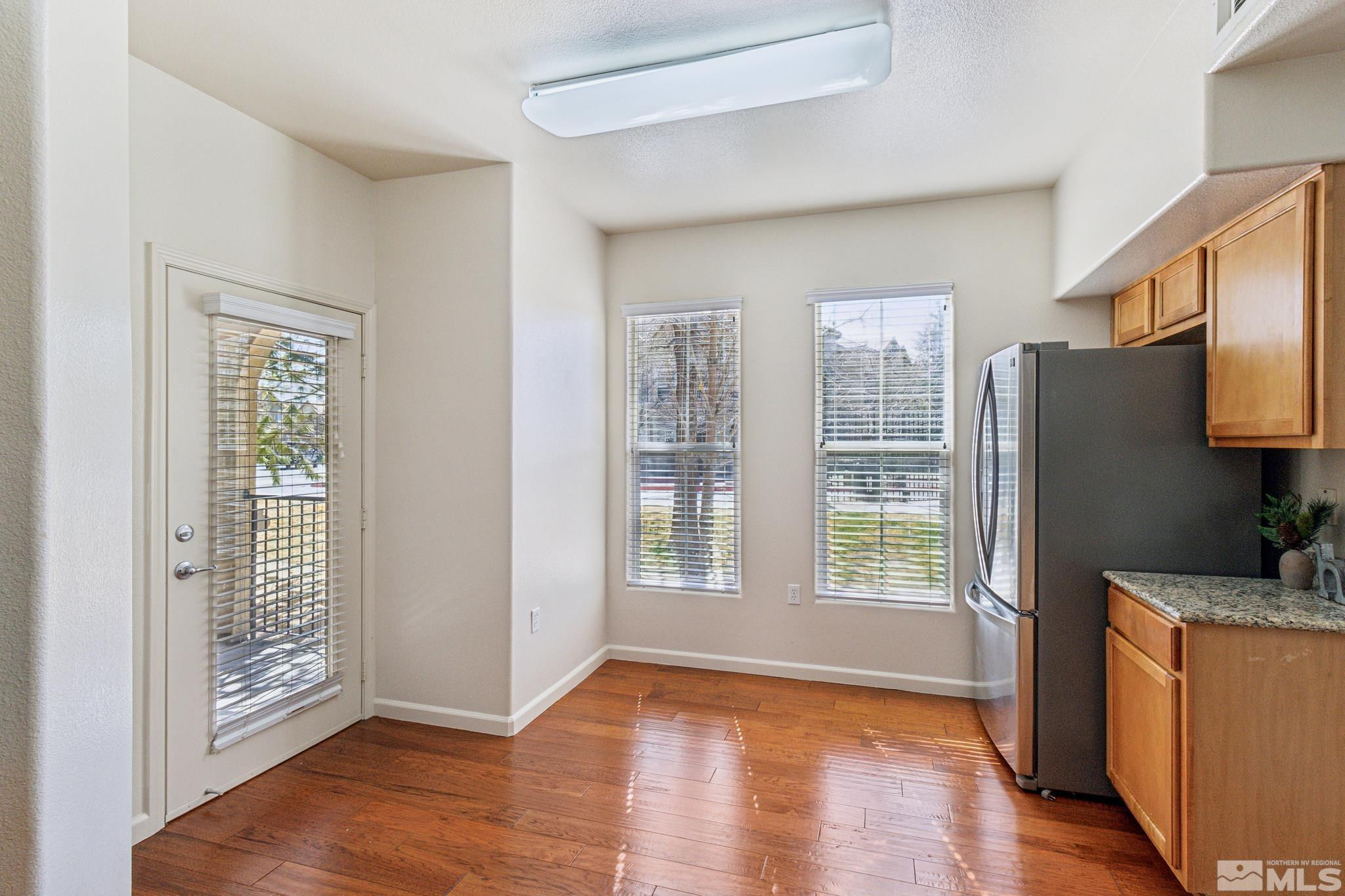 9050 Double R Boulevard, Unit 1412 Reno, NV 89521 - Photo 6 of 18 a view of an empty room with a window and wooden floor
