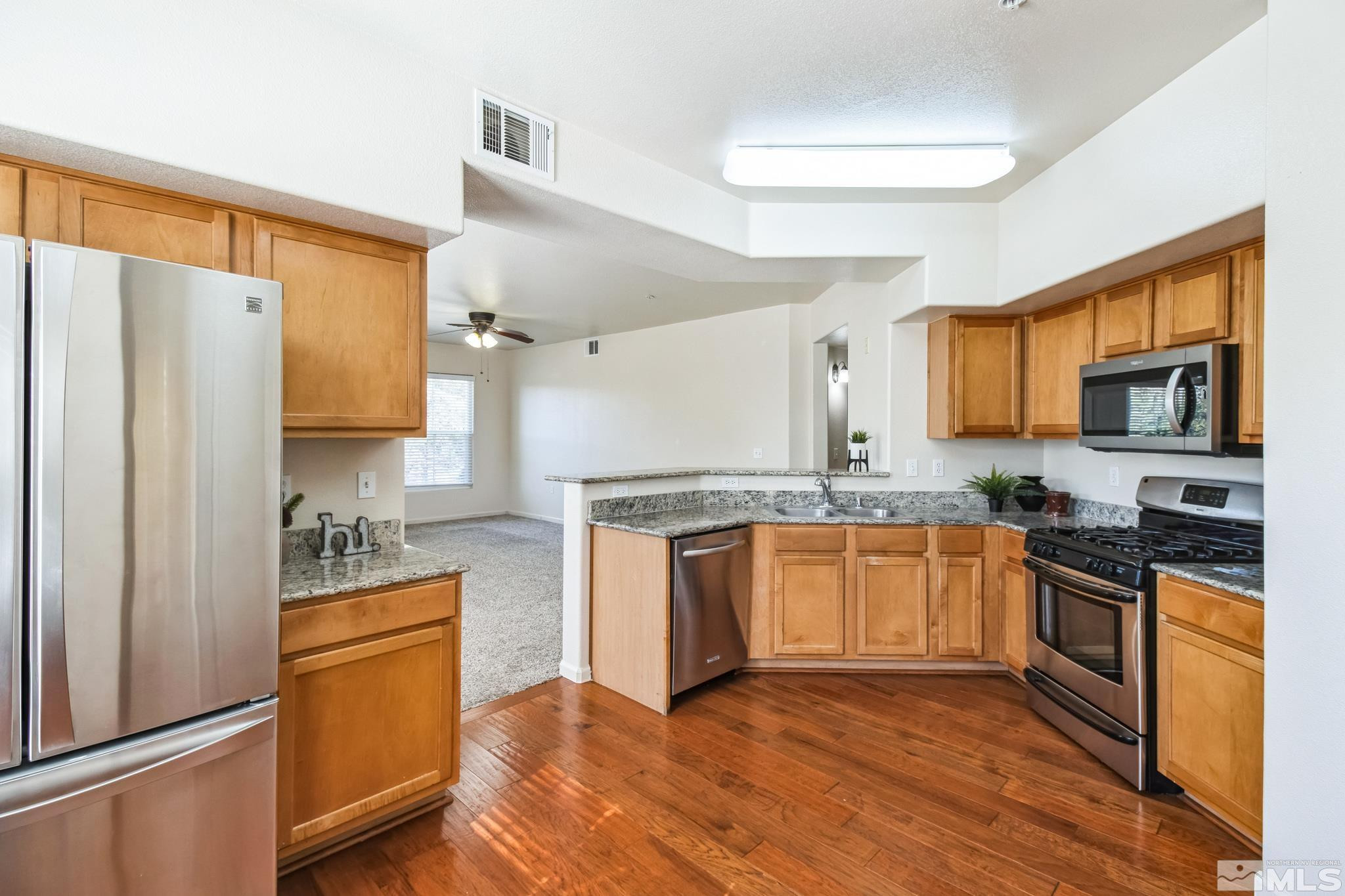 9050 Double R Boulevard, Unit 1412 Reno, NV 89521 - Photo 7 of 18 a kitchen with stainless steel appliances granite countertop a refrigerator stove and sink