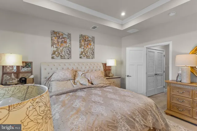 a bedroom with a bed and a flat tv screen on dresser