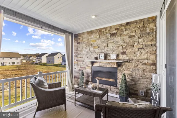 a living room with furniture a fireplace and a floor to ceiling window