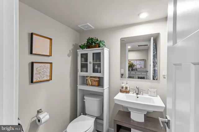 a bathroom with a toilet a sink and mirror