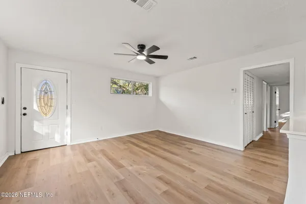 a view of an empty room with wooden floor