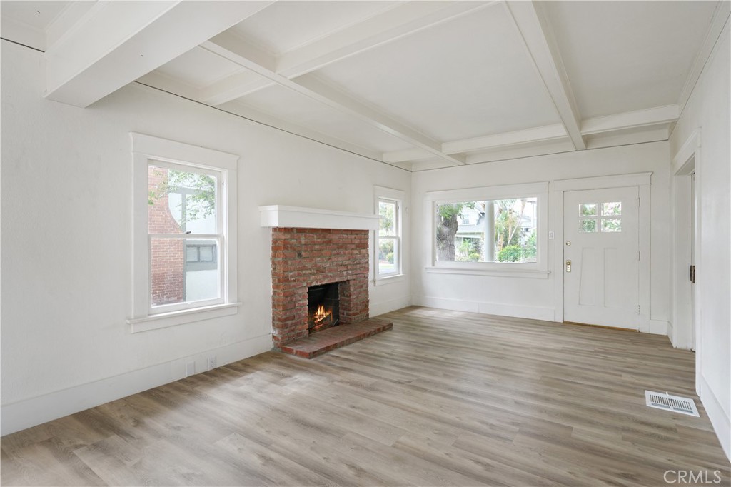 4415 12th Street Riverside, CA 92501 - Photo 7 of 33 an empty room with wooden floor fireplace and windows