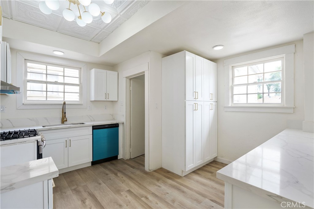 4415 12th Street Riverside, CA 92501 - Photo 8 of 33 a kitchen with stainless steel appliances granite countertop a stove a sink dishwasher and a refrigerator with wooden floor