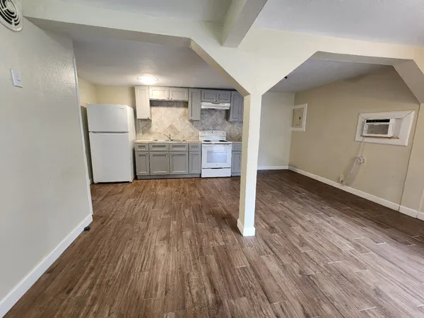 a kitchen with wooden floors and refrigerator