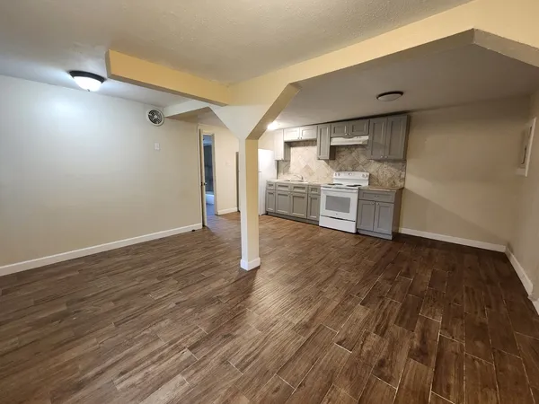 a view of a kitchen with wooden floor and a sink